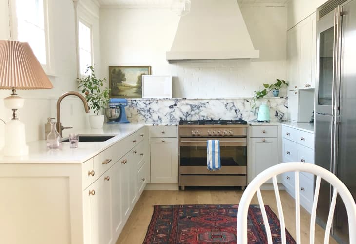 Kitchen with marble backsplash, lamp, and red vintage rug