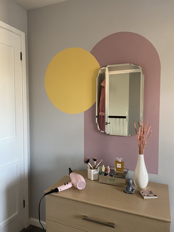 Painted pink arch and mirror above dresser