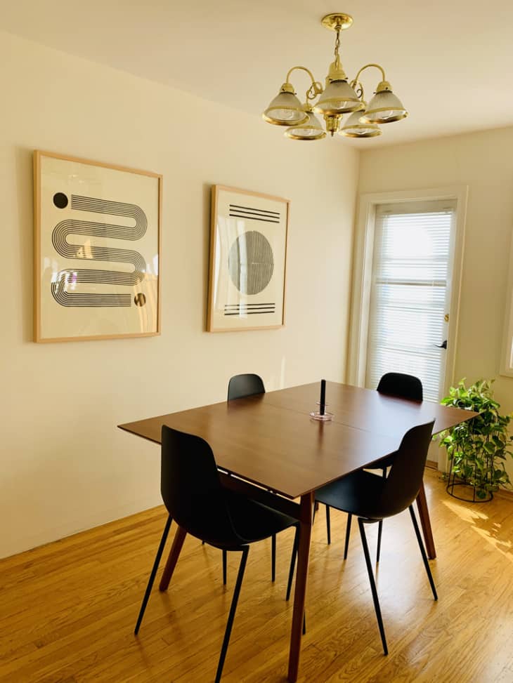 Pristine dining room with black and white geometric wall art and mid-century table and chairs