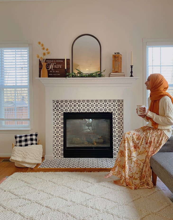 Woman sitting next to fireplace in living room