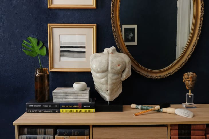 Bedroom cabinet featuring amale bust sculpture, paintings, and a mirror from a 1960s beauty parlor