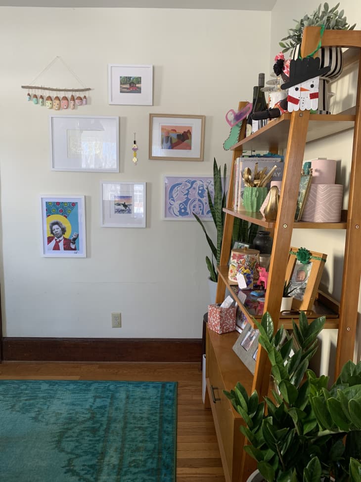 Corner of dining area with colorful artwork on wall and shelf for mementos