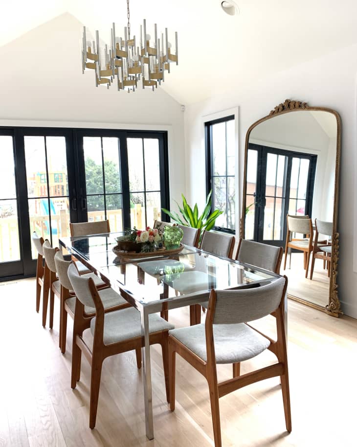 Bright white dining room with large mirror leaning on wall
