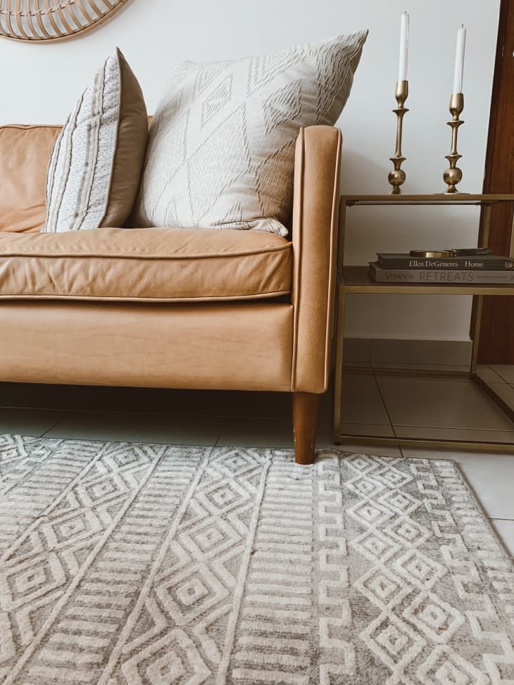 Light brown leather sofa and gray geometric rug