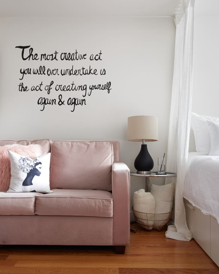 Pink sofa with hand-painted quote above on wall