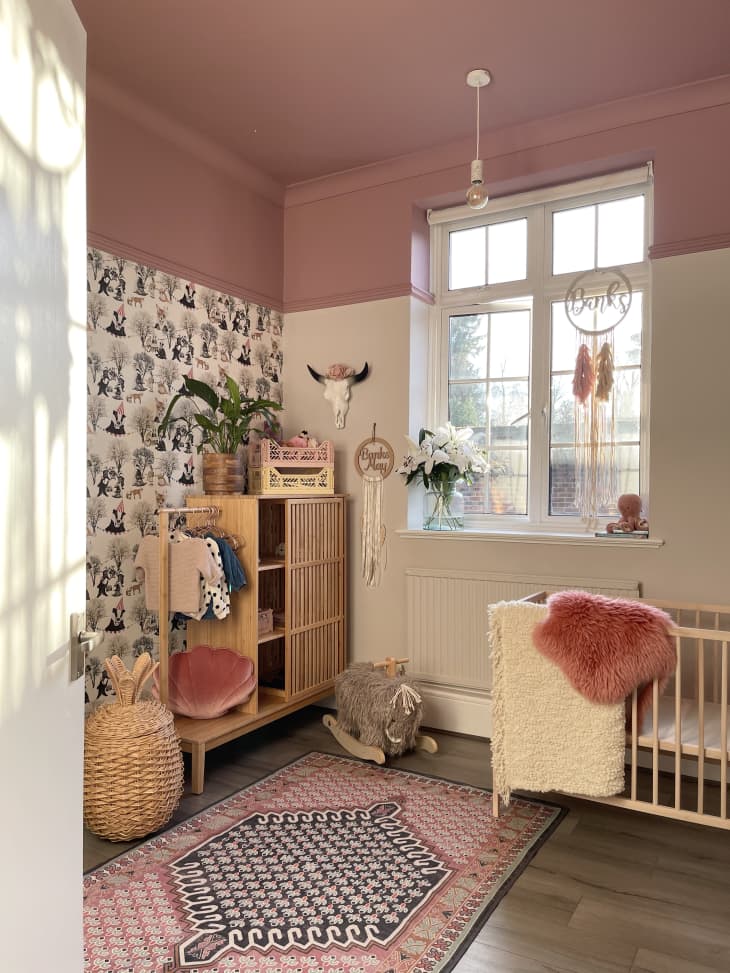 Nursery with pink walls and rug