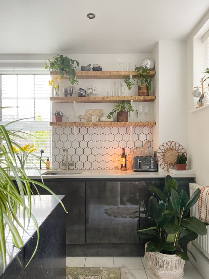 Plant-filled kitchen with white hex backsplash and open shelving