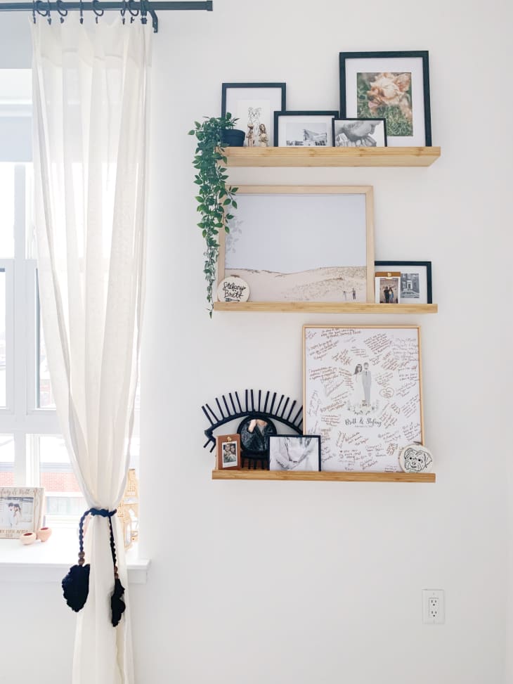 Frames on floating shelves against white wall