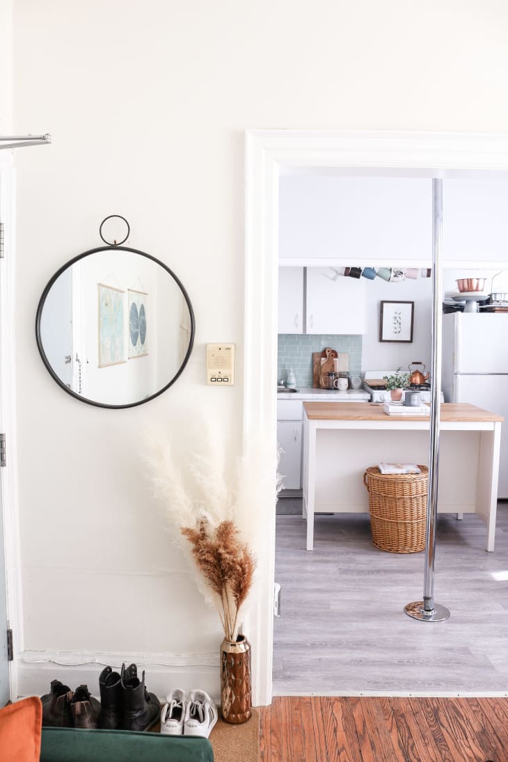White entryway with view into kitchen with pole in it