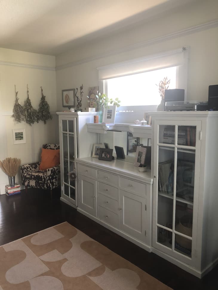 White buffet and glass-front cabinets against wall