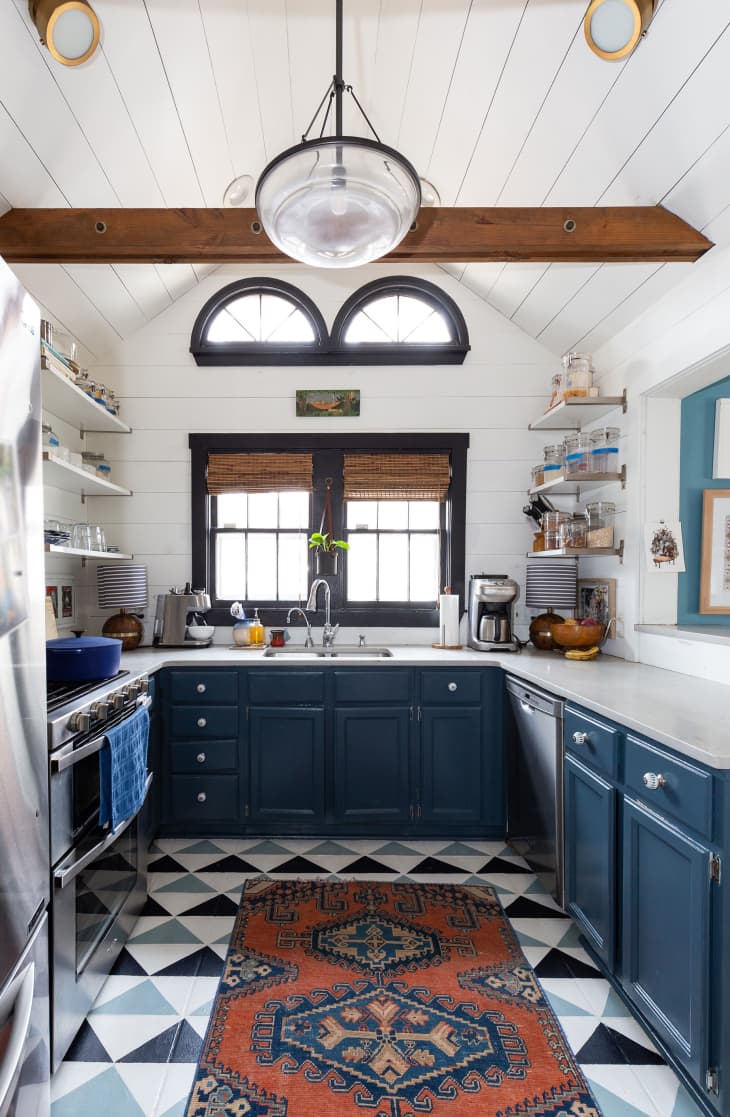 A kitchen with blue cabinets with an a-frame ceiling.