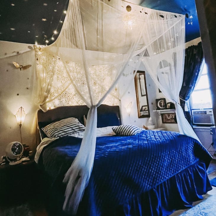 Bed with blue bedding and canopy in bedroom