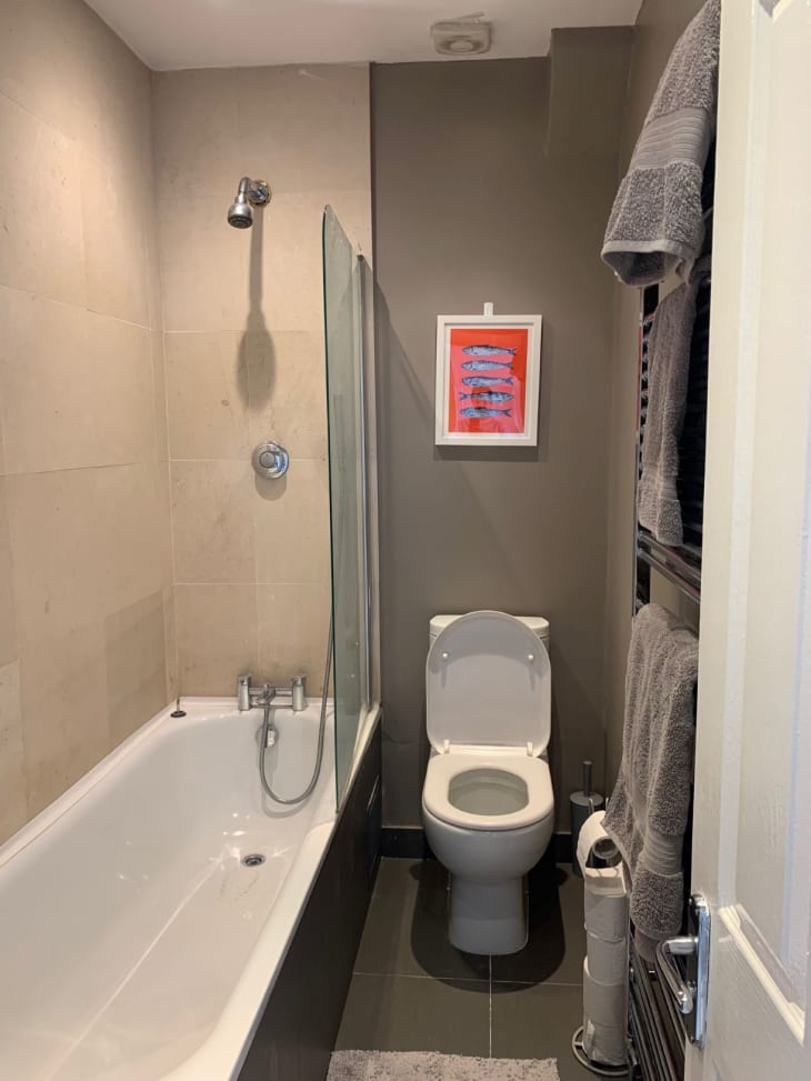 Bathroom with red artwork above toilet