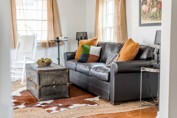 Living room with leather sofa, trunk coffee table, and cowhide rug