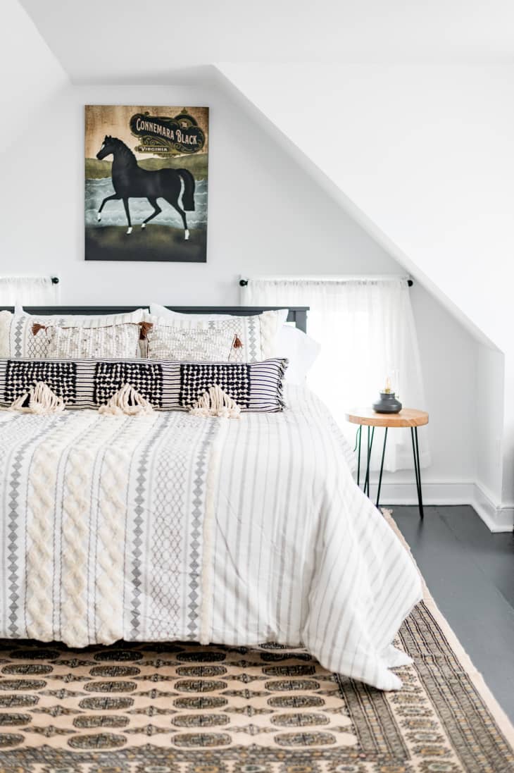 Bright white boho bedroom with horse artwork above bed