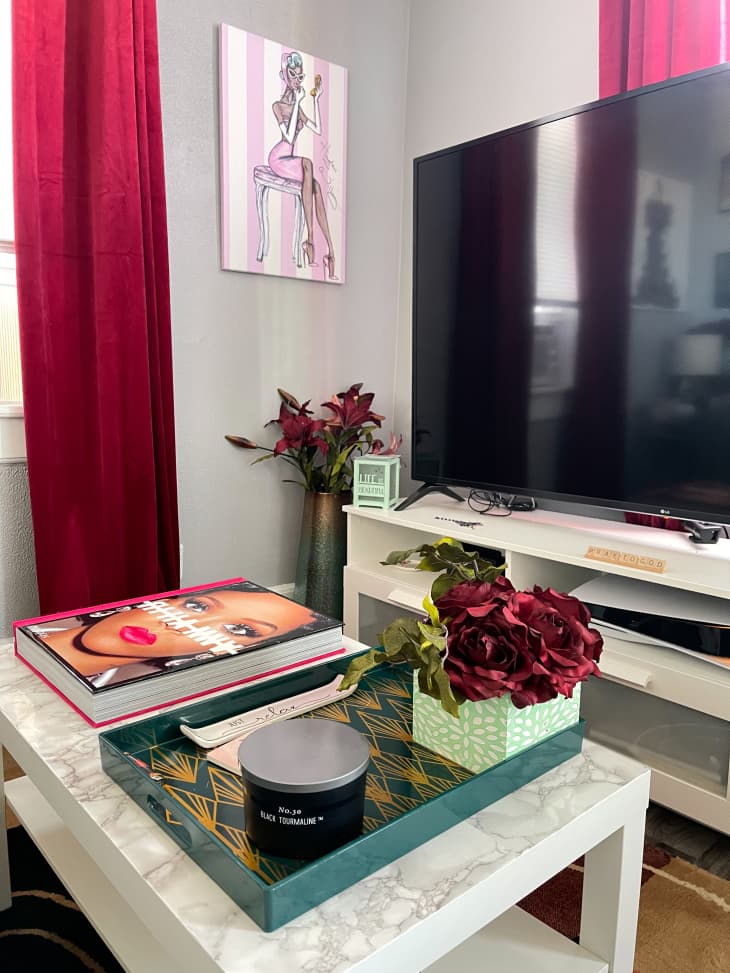 客厅设有大电视，大理石咖啡桌和红色窗帘