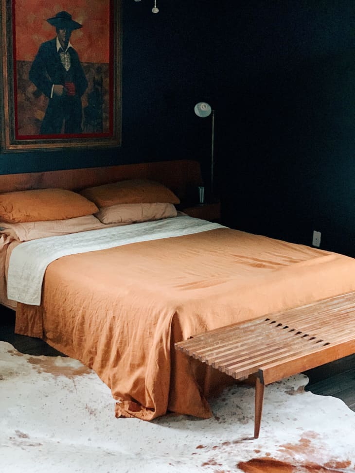 深色海军蓝墙壁和桃红色床上用品的卧室