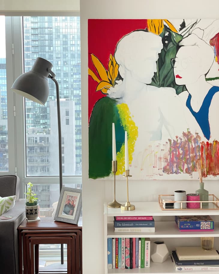 Large colorful artwork above stylized bookshelf  in entryway