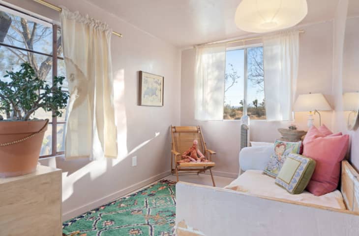 Bright, cozy bedroom with two windows and small daybed