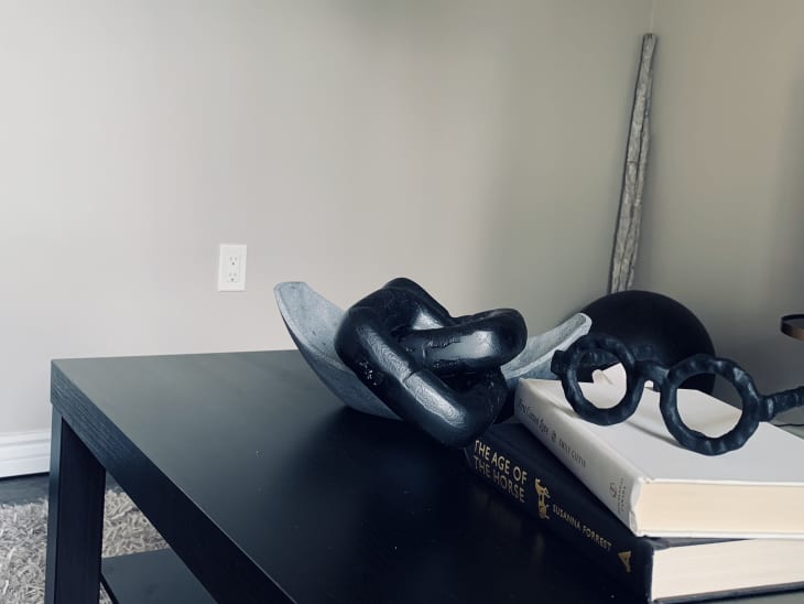 Books and sculptural objects on black coffee table