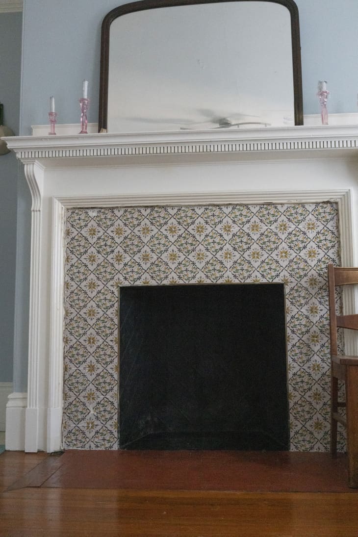 Tiled fireplace with pink candlesticks and mirror on mantel