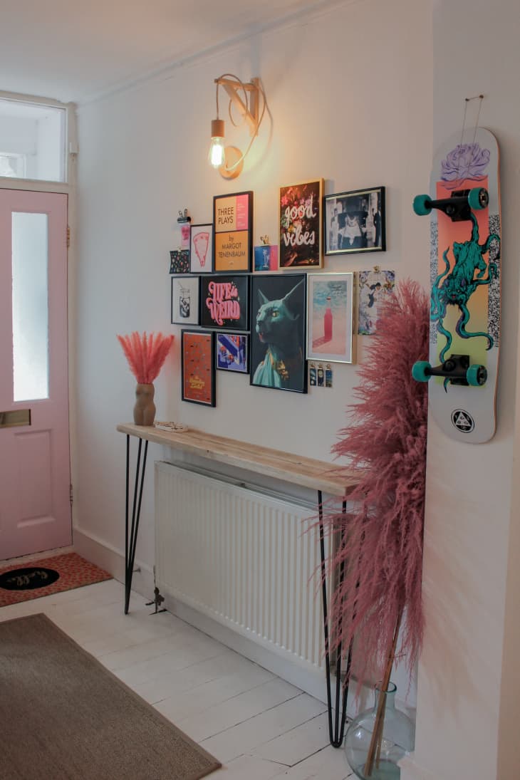 Console table with colorful art above it in entryway
