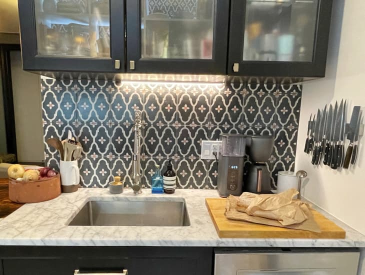 Black motif tile backsplash behind sink