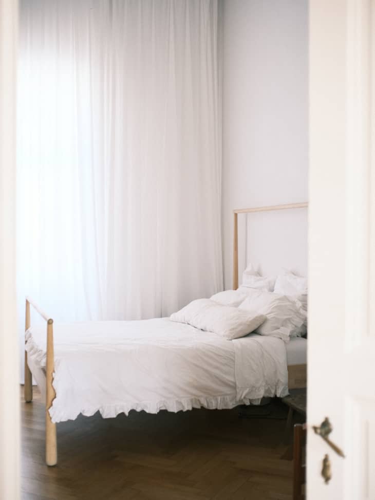 White, airy bedroom with gauzy white curtain
