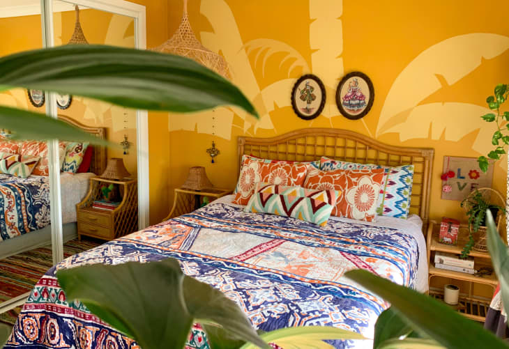 Colorful bedroom with yellow palm leaf mural on wall