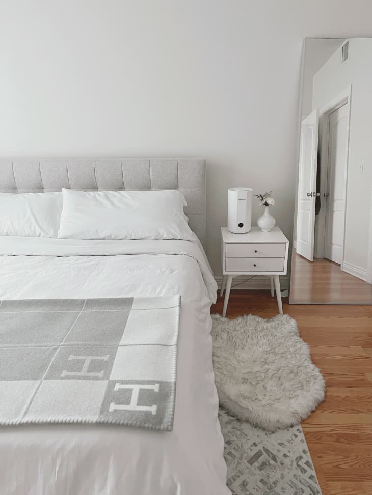 All white bedroom with floor-length mirror in corner