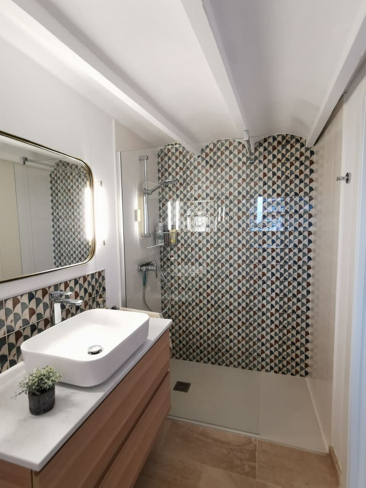 Bathroom with glass-front standing shower and scalloped tile