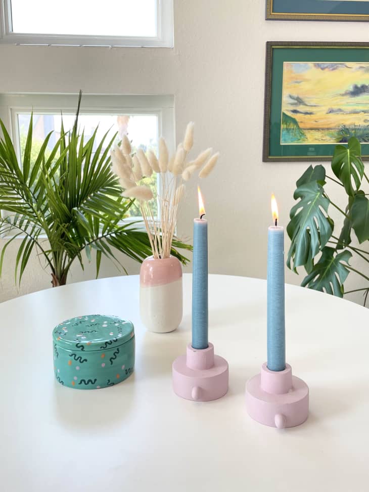 Dining table with blue taper candles and blush-colored vase in center