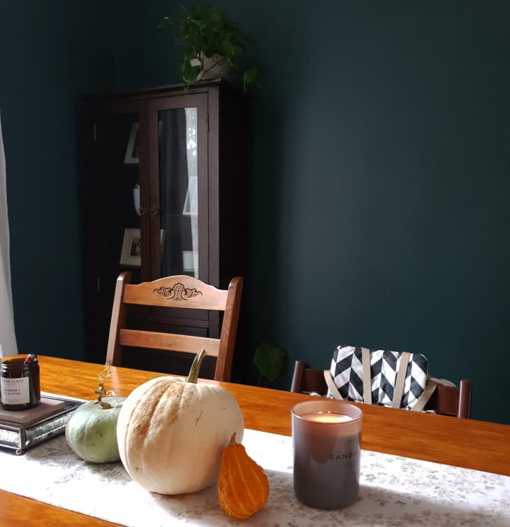 Dining table in room with dark green walls