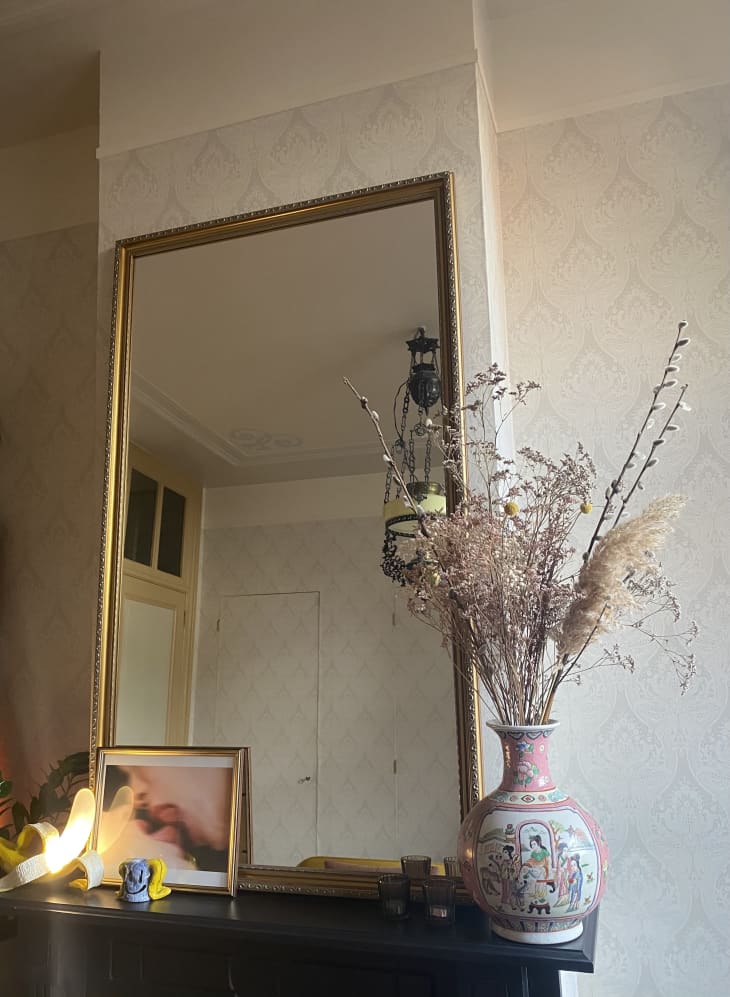 Rectangular mirror, vase, and small framed artwork on ledge