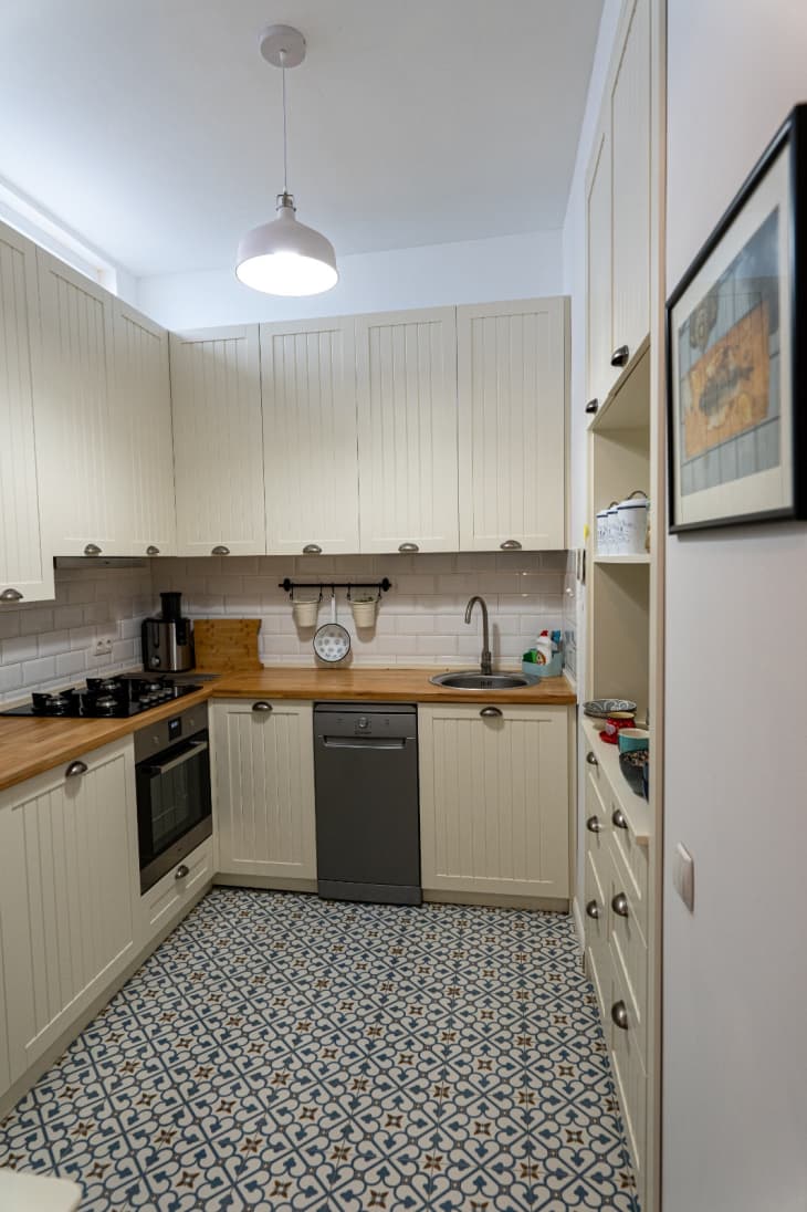 Small kitchen with off-white cabinets, pendant light, and motif tile floors