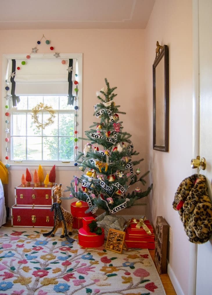 Christmas tree in corner of room with floral rug