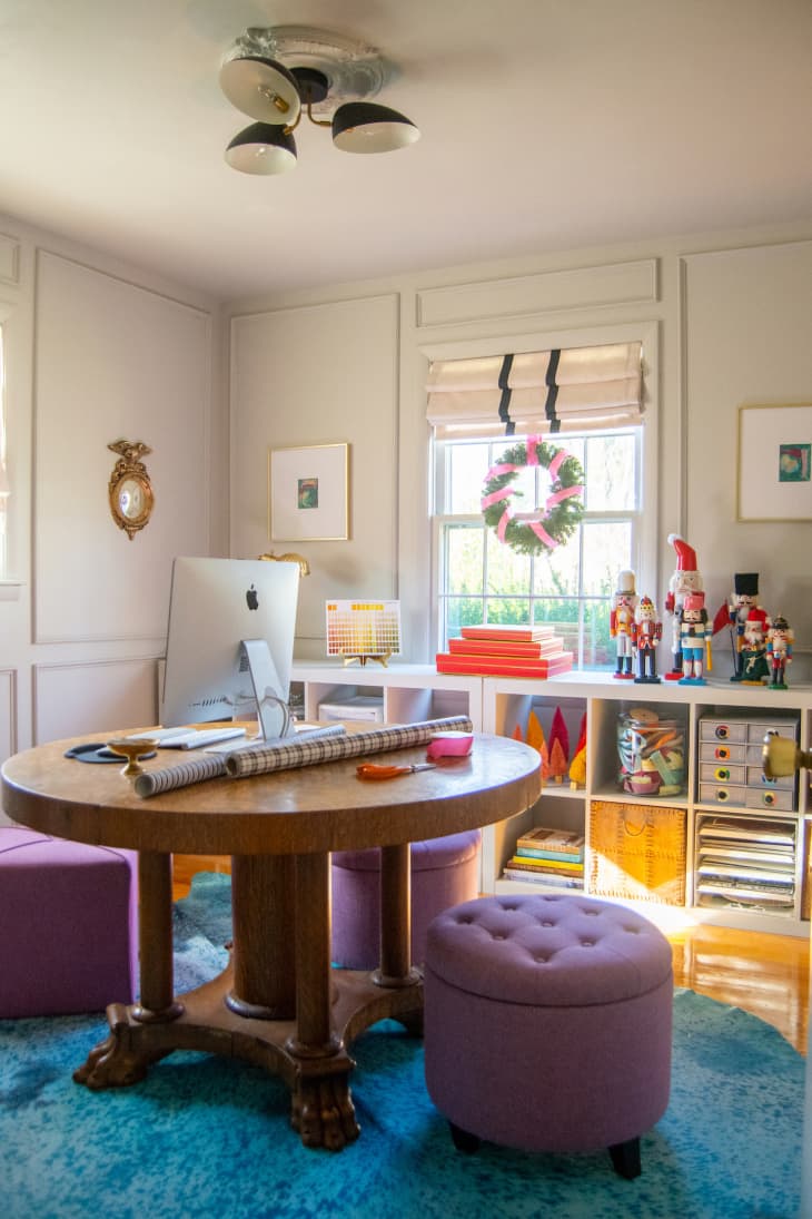Home office with wrapping paper on desk and wreath hanging in window