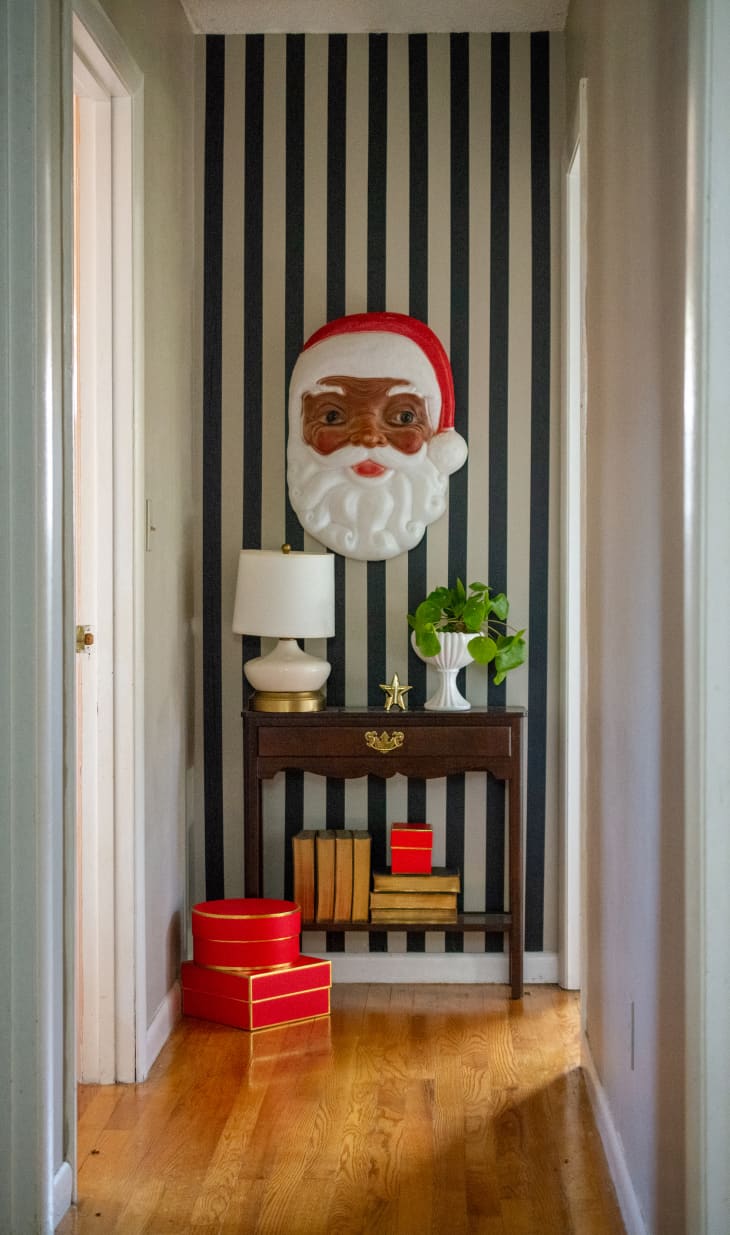 Vintage Santa face hanging above console table in hallway