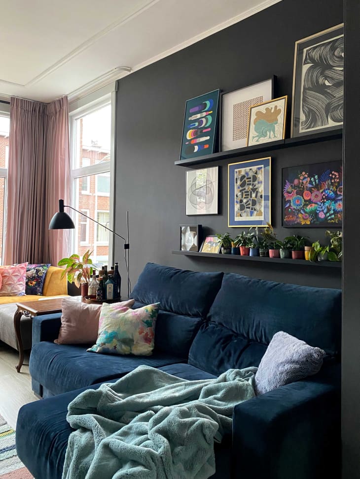 Blue velvet sofa with framed artwork above it