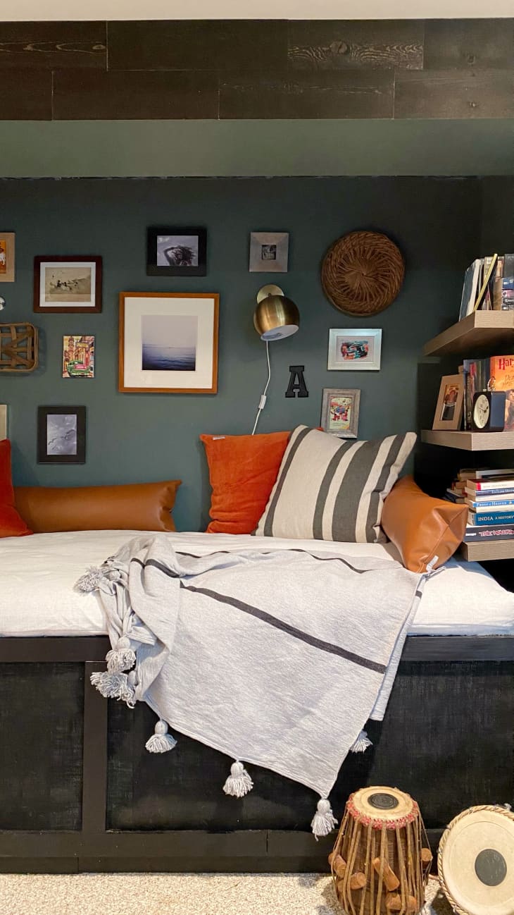 Cozy nook with bench, bookshelves, framed photos, and sconce