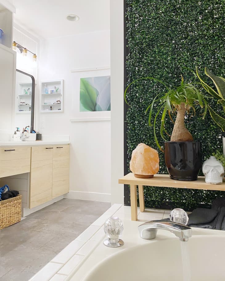 Bathroom with topiary wall near tub