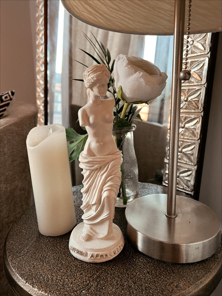 Aphrodite sculpture next to lamp on end table