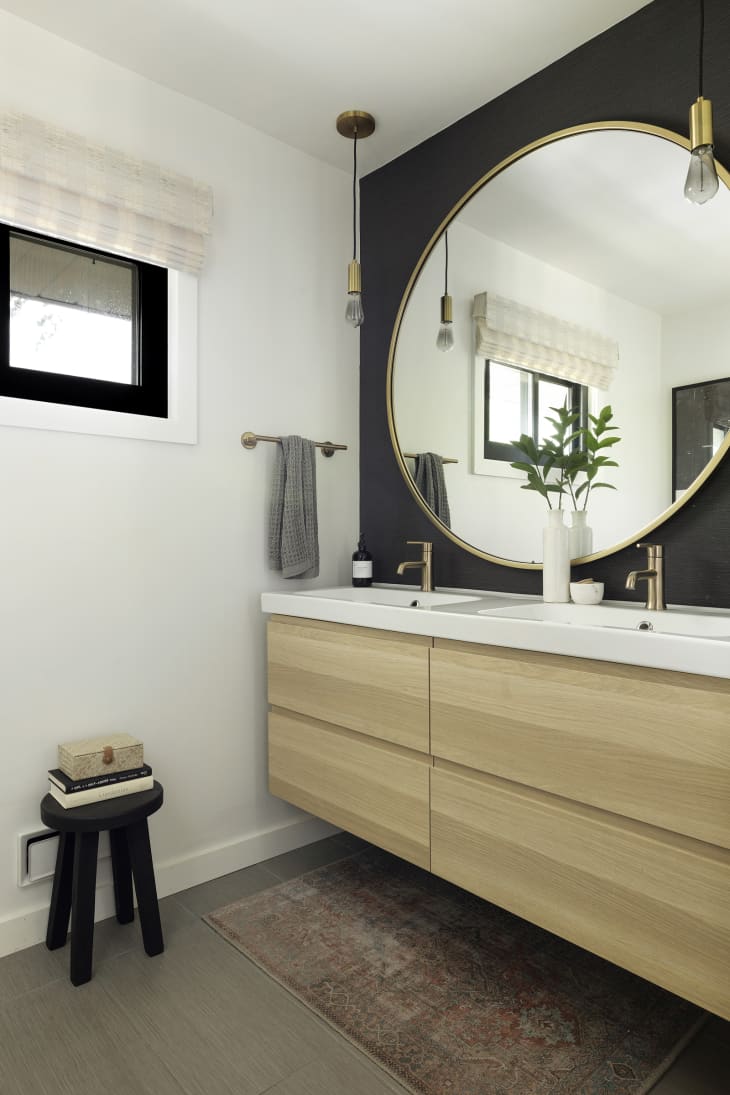 Black, white, and neutral bathroom with large round mirror