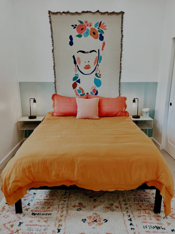 Bed with Frida Kahlo tapestry at head