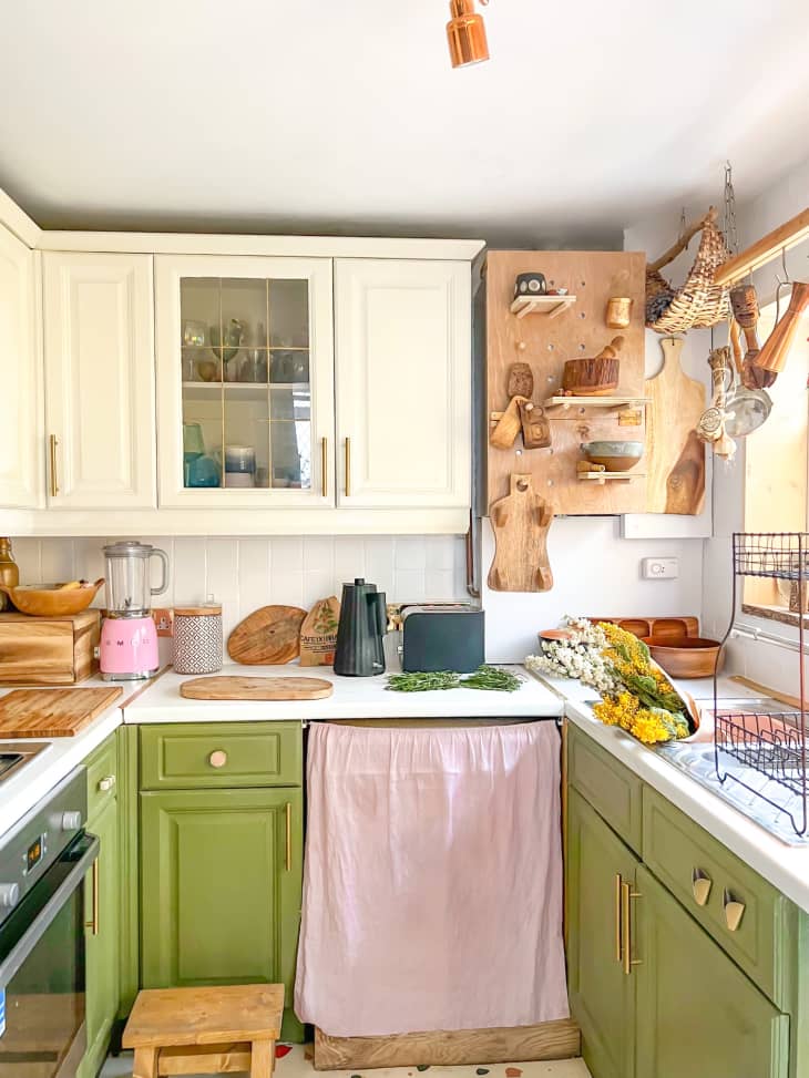 DIY kitchen with green painted bottom cabinets and a peg board storage wall