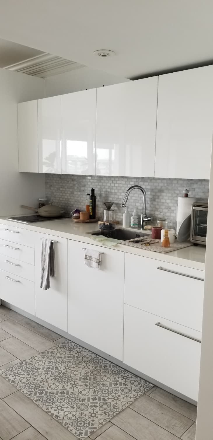 Kitchen area with white shiny cabinets