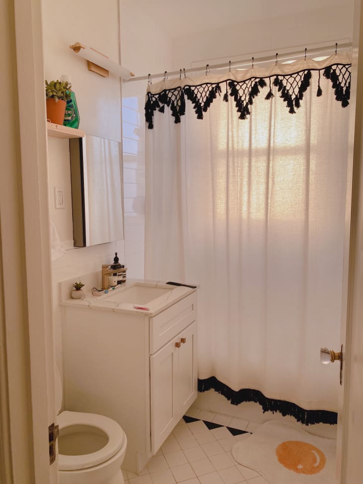 White bathroom with white and black shower curtain
