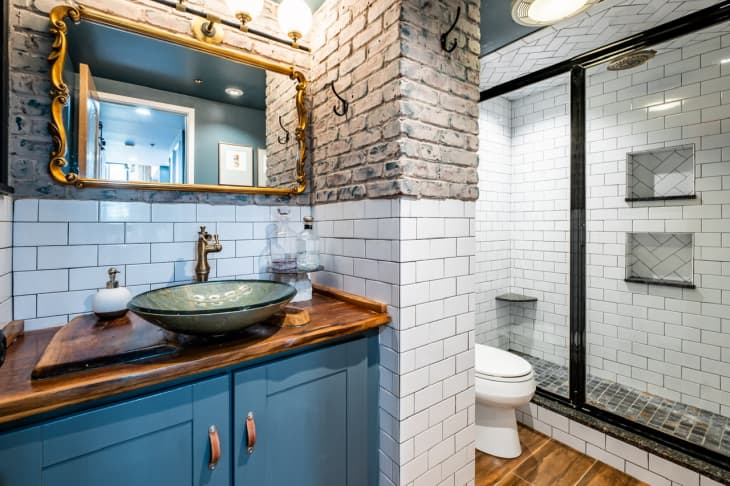 Bathroom with white and gray tiles and blue cabinets