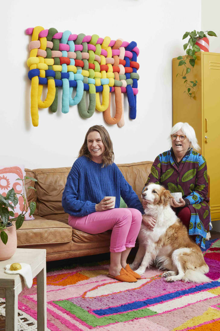 Two people sitting on a couch with a dog