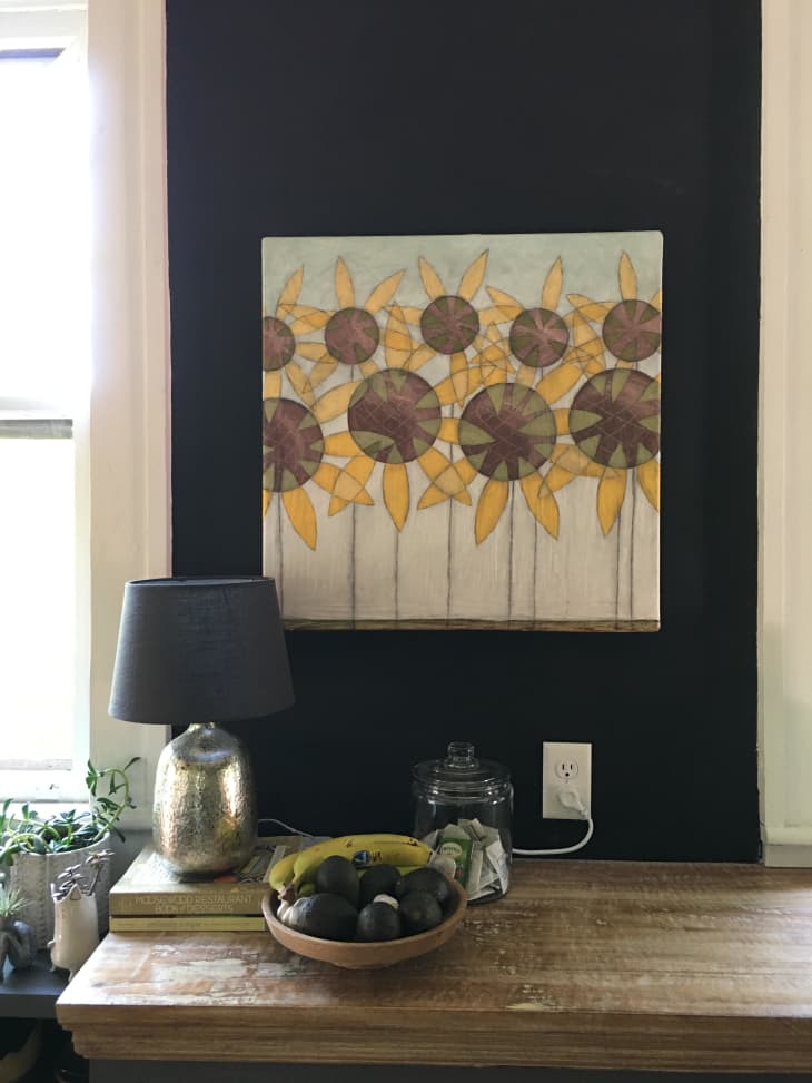 Painting of sunflowers on a blue wall